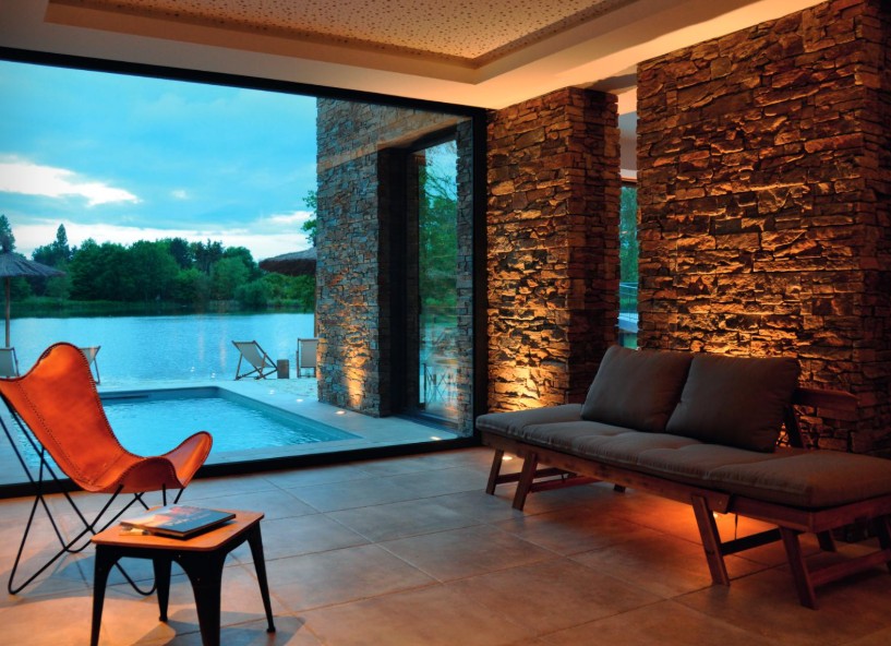 intérieur d'une maison avec une grand baie vitrée et vue sur la piscine